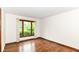 Cozy bedroom featuring hardwood floors, a large window with a view of the outdoors, and neutral wall paint at 8242 Windhaven Cir, Indianapolis, IN 46236