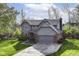 Charming gray home featuring an attached garage, manicured lawn, and mature trees in a peaceful setting at 8242 Windhaven Cir, Indianapolis, IN 46236