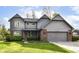 Charming home with an attached two-car garage, gray siding, brick accents and well-maintained lawn and landscaping at 8242 Windhaven Cir, Indianapolis, IN 46236