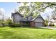 Beautiful gray two-story home with a manicured lawn, brick details, mature trees, and an attached two car garage at 8242 Windhaven Cir, Indianapolis, IN 46236