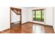Bright living room featuring hardwood floors, staircase, a large window with a view of the outdoors, and neutral wall paint at 8242 Windhaven Cir, Indianapolis, IN 46236