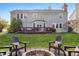 Home's backyard featuring a fire pit with Adirondack chairs and a manicured lawn at 8277 Plumwood Ln, Indianapolis, IN 46256