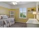 Cozy bedroom with yellow walls, a comfy bed, and bright natural light at 8277 Plumwood Ln, Indianapolis, IN 46256