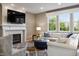 Cozy living room featuring a fireplace, large windows, and comfortable seating arrangement at 8277 Plumwood Ln, Indianapolis, IN 46256