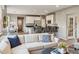 Open-concept living room with a large sectional couch seamlessly connected to the kitchen area at 8277 Plumwood Ln, Indianapolis, IN 46256