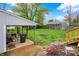 View of backyard with patio area and stairs leading up to the deck, adjacent to the large garage at 840 N Indiana St, Mooresville, IN 46158