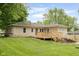 Exterior view of the backyard featuring a new wooden deck and well-maintained lawn at 840 N Indiana St, Mooresville, IN 46158