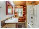 Stylish bathroom with wood paneled walls and tub/shower combo at 840 N Indiana St, Mooresville, IN 46158