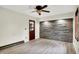 Bedroom featuring a stone accent wall, wood-look floors, and a ceiling fan at 840 N Indiana St, Mooresville, IN 46158