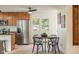 Bright dining area features modern light fixture and seating for four with stainless refrigerator at 840 N Indiana St, Mooresville, IN 46158