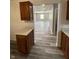 Kitchen view into adjacent room with laminate flooring and wood cabinets at 89 Judy Dr, Martinsville, IN 46151