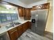 Kitchen features wood cabinetry, ample counter space, stainless appliances, and new laminate flooring at 89 Judy Dr, Martinsville, IN 46151
