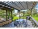 Backyard with a covered deck, outdoor dining area, and a lush lawn leading to a detached garage at 8906 N County Road 1050 E, Brownsburg, IN 46112