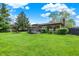 Beautiful brick home featuring a large backyard, wooden deck, and sunroom at 8906 N County Road 1050 E, Brownsburg, IN 46112