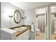 Clean bathroom with a white vanity, oval mirror, and access to a shower with gray tile at 8906 N County Road 1050 E, Brownsburg, IN 46112