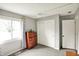Neutral bedroom features a window with patterned curtains, and a vintage wooden dresser at 8906 N County Road 1050 E, Brownsburg, IN 46112