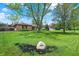 Landscaped front yard featuring a large shade tree and a decorative stone with the house number at 8906 N County Road 1050 E, Brownsburg, IN 46112