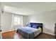 Cozy bedroom with a blue bed, hardwood floors, and soft natural light from the window at 8906 N County Road 1050 E, Brownsburg, IN 46112