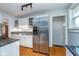 Kitchen with stainless steel refrigerator, granite counters and view to front door at 914 Kessler Blvd E Dr, Indianapolis, IN 46220