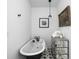 Elegant bathroom featuring a clawfoot tub, striking black and white star-patterned tile, and mirrored dresser at 946 Stillwell St, Indianapolis, IN 46202