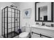 Modern bathroom with black framed shower, patterned tile floor and white vanity with dark fixtures at 946 Stillwell St, Indianapolis, IN 46202