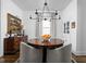 Chandelier hangs above a wood table in a dining room with vintage artwork on the wall at 946 Stillwell St, Indianapolis, IN 46202