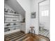 Stylish hallway with open shelving, hardwood floors, and doorway leading to a bathroom at 946 Stillwell St, Indianapolis, IN 46202