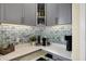 Close-up of wet bar area with cabinetry, counter space, coffee maker, and decorative backsplash at 10294 Pigato Dr, Zionsville, IN 46077
