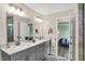 Modern bathroom features double sinks, quartz countertops, with a view looking into a bedroom at 10294 Pigato Dr, Zionsville, IN 46077