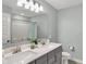 Bathroom featuring a double vanity, modern fixtures, a large mirror, toilet, and a shower with a shower curtain at 10294 Pigato Dr, Zionsville, IN 46077