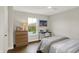 Bright bedroom featuring hardwood floors, a desk with chair, dresser with lamp and decor and large window with natural light at 10294 Pigato Dr, Zionsville, IN 46077
