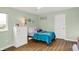 Bright bedroom featuring hardwood floors, turquoise walls, white dresser and bed with turquoise bedding at 10294 Pigato Dr, Zionsville, IN 46077