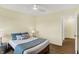 Bedroom featuring hardwood floors, a queen size bed, lamps and a view to the hallway at 10294 Pigato Dr, Zionsville, IN 46077