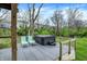 Relaxing deck featuring a hot tub and lounge chairs overlooking a wooded backyard at 10294 Pigato Dr, Zionsville, IN 46077