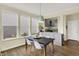 Bright dining area features wood floors, a modern light fixture, and ample windows with backyard views at 10294 Pigato Dr, Zionsville, IN 46077