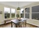 Bright dining room with large windows, and views of the outside, and a dark wood table at 10294 Pigato Dr, Zionsville, IN 46077