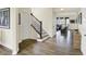 Welcoming entryway featuring beautiful wood floors, a staircase with iron railing, and natural light from the living room at 10294 Pigato Dr, Zionsville, IN 46077