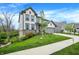 Inviting two-story home boasts a lush green lawn, complemented by a neutral gray facade and orange front door at 10294 Pigato Dr, Zionsville, IN 46077