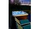 Hot tub and seating on a deck in the backyard with landscape lighting at 10294 Pigato Dr, Zionsville, IN 46077