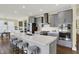 Modern kitchen featuring stainless steel appliances, a white countertop island with seating, and grey cabinetry at 10294 Pigato Dr, Zionsville, IN 46077