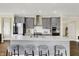 Modern kitchen featuring stainless steel appliances, a white countertop island with seating, and grey cabinetry at 10294 Pigato Dr, Zionsville, IN 46077