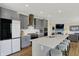 Modern kitchen featuring stainless steel appliances, a white countertop island with seating, and grey cabinetry at 10294 Pigato Dr, Zionsville, IN 46077