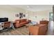 Comfortable living room featuring an orange couch, glass coffee table, and tan colored hardwood flooring at 10294 Pigato Dr, Zionsville, IN 46077
