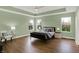 Charming main bedroom with an abundance of natural light, hardwood floors and decorative lamps on each bedside table at 10294 Pigato Dr, Zionsville, IN 46077