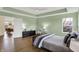 Spacious main bedroom with hardwood floors, tray ceilings and comfortable seating near the side windows at 10294 Pigato Dr, Zionsville, IN 46077