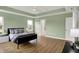 Bright main bedroom with hardwood floors, natural light, a tray ceiling and a comfortable dark colored bed at 10294 Pigato Dr, Zionsville, IN 46077
