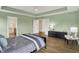 Well lit and comfortable main bedroom with hardwood floors and tray ceilings, leading to an ensuite bathroom at 10294 Pigato Dr, Zionsville, IN 46077