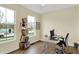 Bright home office with wood floors, a functional desk, and plenty of natural light from large windows at 10294 Pigato Dr, Zionsville, IN 46077