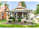 Charming home with an inviting front porch, lovely landscaping, and classic architectural details at 1030 N Butler Ave, Indianapolis, IN 46219