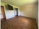 Spacious bedroom with laminate wood flooring, a wall-mounted television, and an open closet at 10569 Folsom Dr, Indianapolis, IN 46235